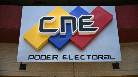 The logo of Venezuela's National Electoral Council (CNE) is seen on the facade of its headquarters in Caracas on March 5, 2024. - Presidential elections in Venezuela will be held on July 28, in the second half of the year, as agreed between the government and the opposition at a negotiating table, the electoral authority informed on Tuesday. (Photo by Federico Parra / AFP)